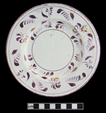 Painted floral luster decoration on white earthenware saucer.